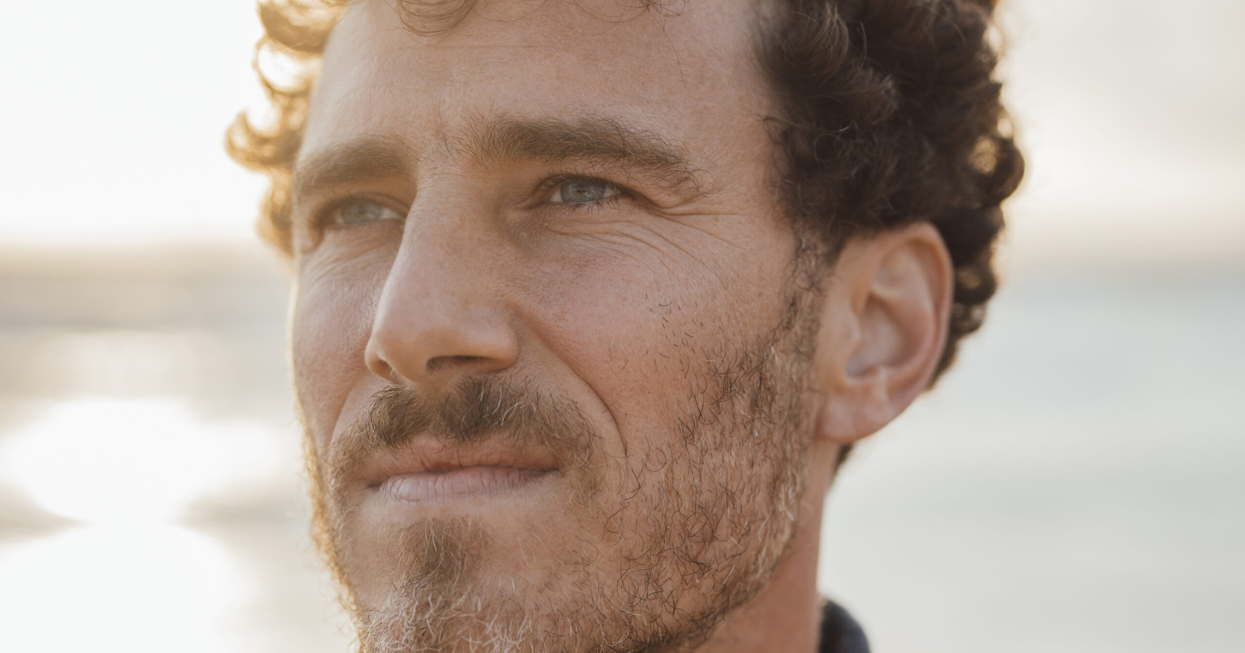 Thoughtful man wearing turtleneck sweater at beach